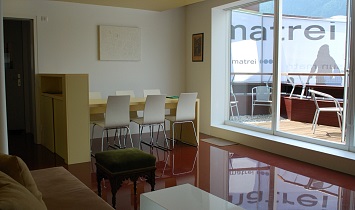 Design Wohnraum mit Esstisch, Couch und Zugang zur Terrasse