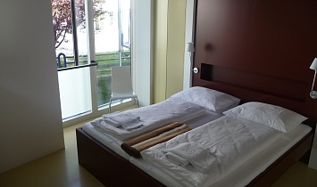Doppelbett im Design Appartement mit Blick in den Garten