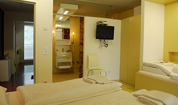 Dreibettzimmer mit Fernseher und Bad im Design Apartment SUN Matrei