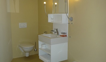 Spacious bathroom with bath, wash basin, mirror and toilet in one of the XL Design apartments