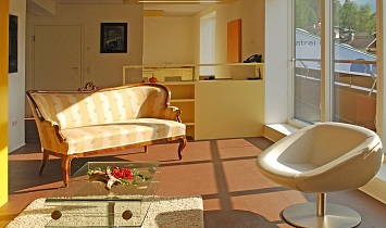 Großer Wohnraum mit klassischem Möbelstück in einem Design-Apartment