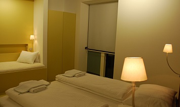 Schlafzimmer mit Doppelbett und Einzelbett im Design Appartement für 1 bis 3 Personen